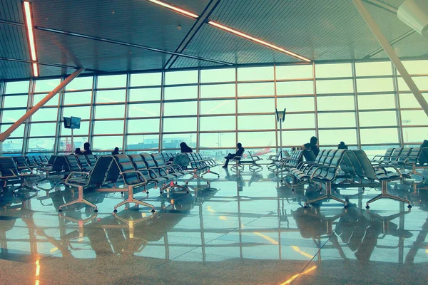 Siluetas de personas esperando el vuelo en el aeropuerto — Foto de Stock