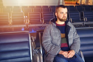 Sakallı genç bir adam onun uçuş havaalanında bekler.