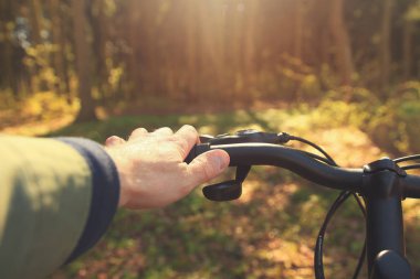 Bahar adam açık havada ormanda bir bisiklet sürme yakın çekim.