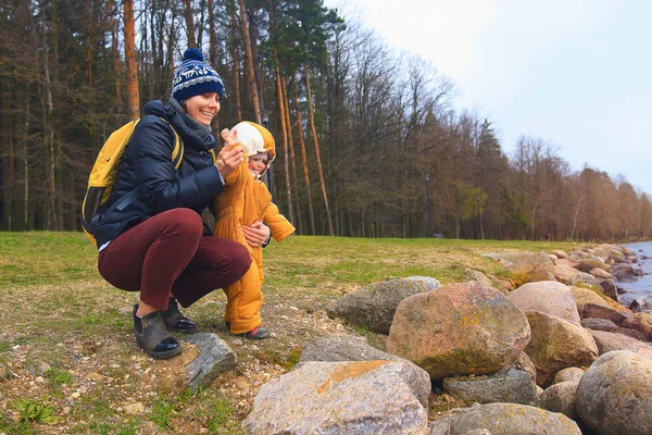 Mutter und Tochter werfen im Urlaub Steine ins Wasser. glückliche Menschen — Stockfoto