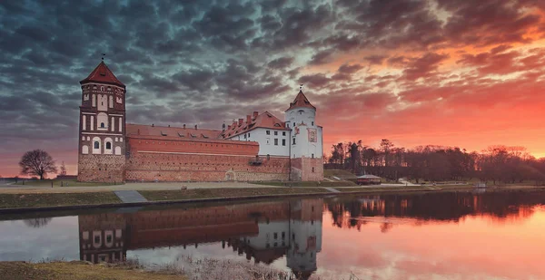 Krajina starého hradu Mirsky proti barevné nebe na krásné svítání. — Stock fotografie