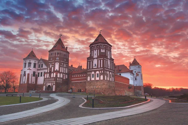 Paisagem de um castelo Mirsky velho contra um céu colorido em uma bela aurora . — Fotografia de Stock