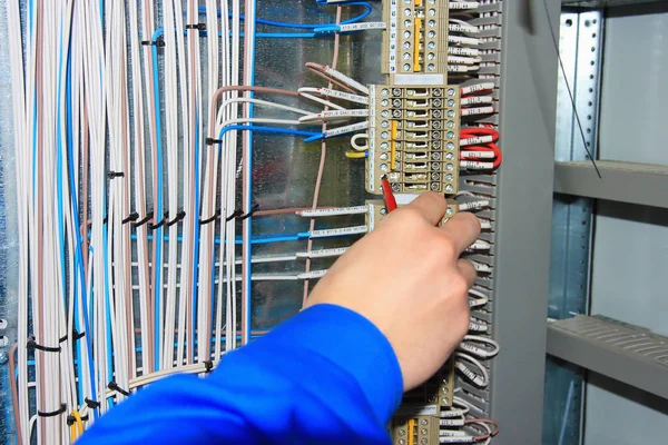 A villanyszerelő kéz végzi a vezetékeket az elektromos szekrény-terminálok. — Stock Fotó