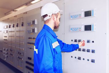 Mühendisi enerji santrali kontrol paneli üzerindeki kırmızı düğmeye basar.