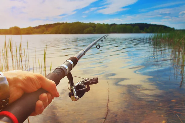 Pescador está pescando en un lago del bosque al aire libre en un día de verano brillante —  Fotos de Stock