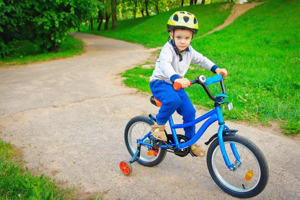 Anak kecil bersepeda di taman hijau di musim panas . — Stok Foto