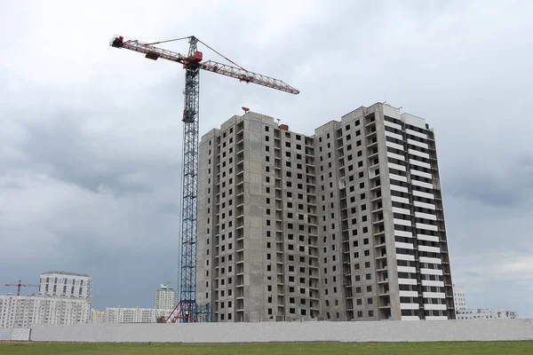 Bouw van een appartementencomplex met een kraan. — Stockfoto