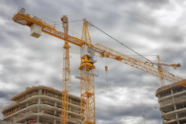 Yeni binaların endüstriyel inşaat. Beton binalar yakınındaki inşaat sitesinde vinç.