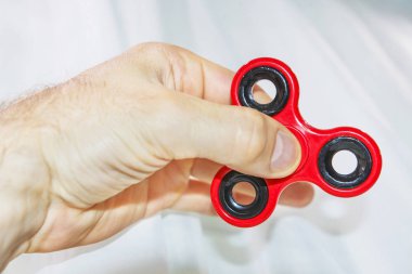 Erkek el, popüler hareketli döner oyuncağı tutuyor.