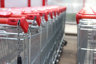 Alışveriş arabaları satır hypermarket yakınındaki ayakta, Kırmızı saplı. Alışveriş arabası portre. Alışveriş kavramı.