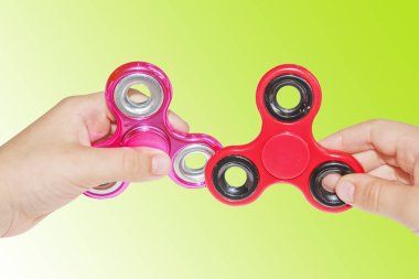 İki yeşil zemin üzerine çocuğun elinde spinners kıpır