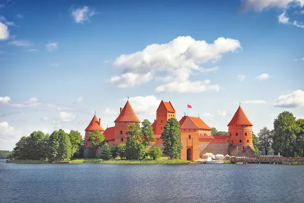 Тракайский замок в Литве в яркий солнечный день. Туризм в Вильнюсе Тракайский замок против голубого неба с облаками — стоковое фото
