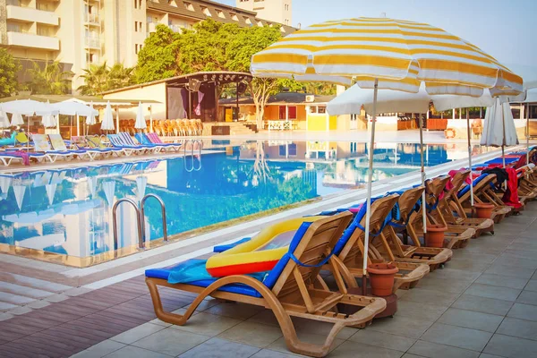 夏のトロピカル リゾート ホテルのプールの近くのサンベッドと太陽のパラソル。トルコ — ストック写真