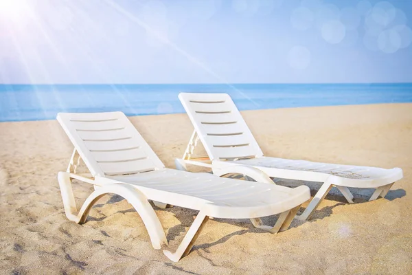Dos chaise lounges en el resort de playa tropical. Vacaciones conceptuales. Playa, arena y mar — Foto de Stock