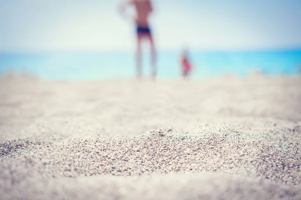 Playa de arena de mar, personas borrosas en la playa del complejo tropical. Concepto de vacaciones — Foto de Stock