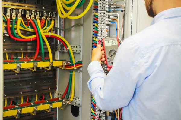 Yüksek gerilim panelinde multimetre ile mühendis