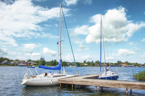 Yates en el lago en el día claro de verano. Yates blancos o barcos contra el cielo azul con nubes —  Fotos de Stock