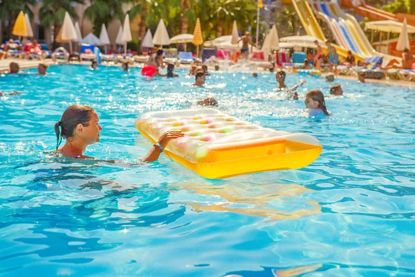 Människor simma i poolen på resort hotel på semester. Glad sommarsemester i tropical hotel — Stockfoto