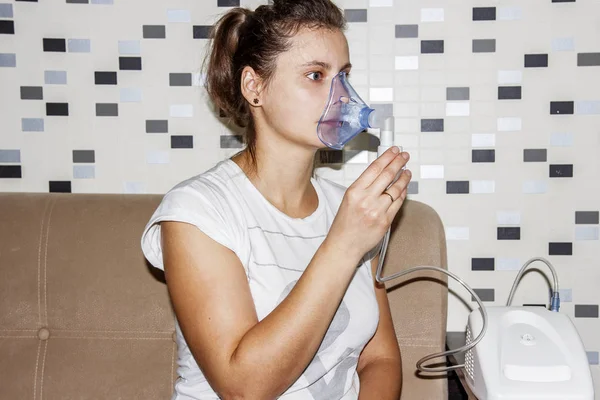 Женщина использует ингалятор дома, когда кашляет. Лечение заболеваний органов дыхания. Ингаляция бронхитом . — стоковое фото