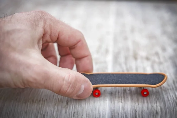 Mão masculina começa skate brinquedo. A começar o conceito de negócio. Startup conceito de empresa jovem. Abstrato começar conceito . — Fotografia de Stock