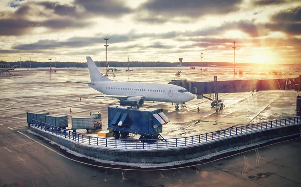 Havaalanı terminal günbatımında uçakta. Uçak kalkış daha önce kontrol hizmeti iş. Havaalanında yatılı.