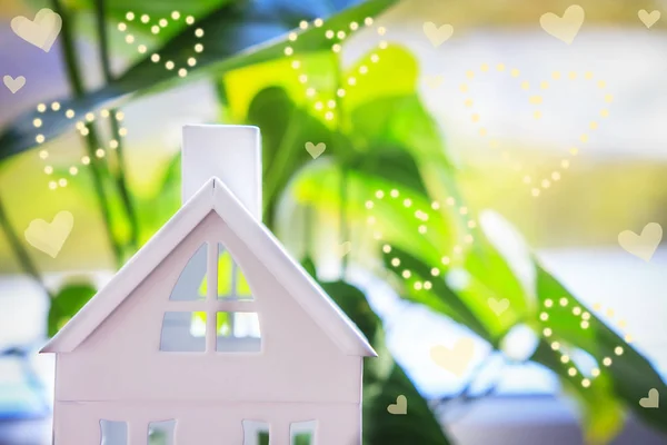 Huis op groene achtergrond met warmte bokeh. Home verzekering concept — Stockfoto