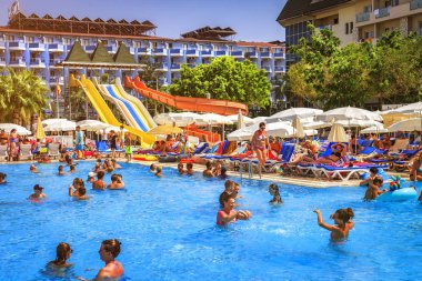 Konaklı, Türkiye - 18 Ağustos 2017: su park resort tropikal otel Yüzme Havuzu. Mutlu insanlar yüzmek ve parlak güneşli gün havuz mavi su ile rahatlayın. Türk tatil yaz tatili.