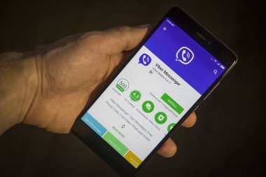 Berlin, Almanya - 19 Kasım 2017: Modern smartphone Viber yükleme menüsü ekranda olan elinde. Telefonda viber app. Uygulama simgesi