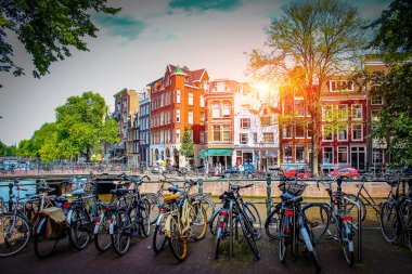 Amsterdam. Hollanda'nın başkentinde gün batımında Park bisiklet eski şehrin arka plan üzerinde. Amsterdam'da yürüyüşleri için sokakları.