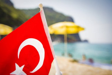 Deniz plaj gün güneşli yaz arka plan üzerinde Türk bayrağı. Tropikal resort ve dinlenme Türkiye kumsallarında kavramı. Yaz tatillerini Türkiye'de.