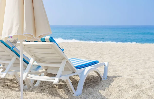 Сонячна парасолька і шезлонг на морському пляжі. Білий пісок і море в тропічному курорті. Концепція пляжного відпочинку. Відпочинок і відпустка . — стокове фото
