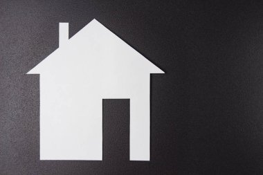 Siyah arka plan üzerine beyaz kağıt ev. Konsept ev. Sigorta ve konut alımı