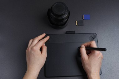 fotoğrafçı fotoğraf grafik tablet kalemi ile işler. Artist's workbench fotoğrafçıdır
