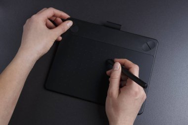 Sanatçı grafik tablet üzerinde çizer. Tasarım konsepti. Yaratıcı çalışma. El sanat grafik tablet ve kalem ile masada.