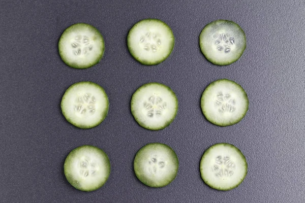 Fatias de pepino verde no fundo de cerâmica preta . — Fotografia de Stock