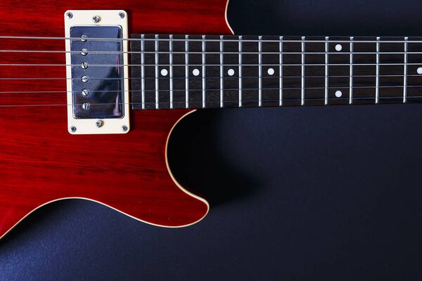 Red electric guitar on black background closeup. Music concept