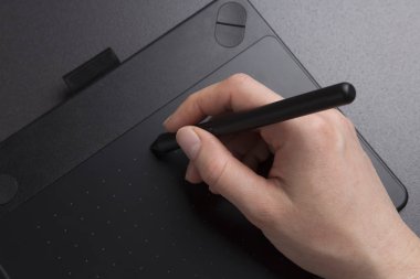 sanatçı siyah grafik tablet yakın çekim çizer. tasarımcının el grafik tablet kalemiyle