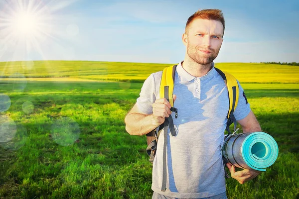 Ein junger gutaussehender Mann picknickt an einem strahlend sonnigen Frühlingstag. Ruhe an der frischen Luft und im Freien. Ausflug zum Picknick auf dem grünen Rasen auf der Wiese oder im Park. — Stockfoto