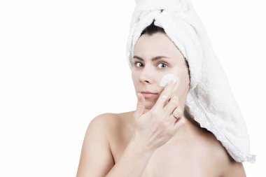 Spa kız beyaz arka plan üzerinde izole yüz maskesi uygulamak. Güzellik bakımı. Güzellik ve vücut cilt bakım kavramı. Çekici kız yüzü krem maske
