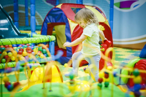Ребенок играет в детской комнате. Дети в развлекательном центре. Веселье в детской игровой комнате . — стоковое фото