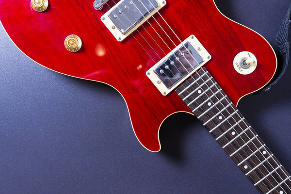 Red electric guitar on black background close-up. Music concept