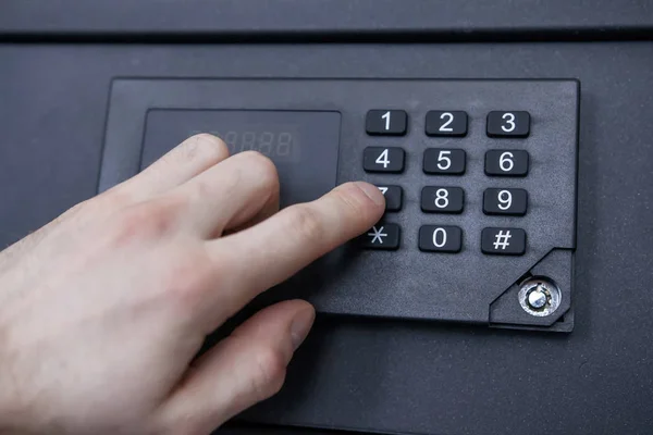 man enters code from safe close-up. Hand, safe, numbers. Safely store money and jewelry at home.