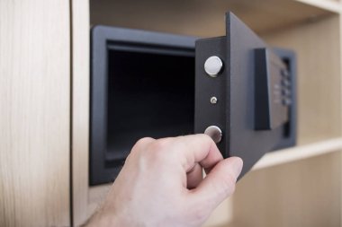 Elektronik kilit ile güvenli kapıyı açın kapatın. Para ve mücevher evde tutmak. adamın el ve güvenli daire.