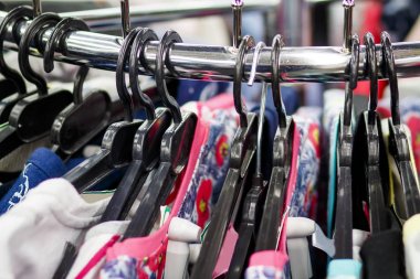 Askıları ile moda giyim butik yakın çekim giysilerle. Alışveriş giyim kavramı. Depodaki askıları şeylerde.