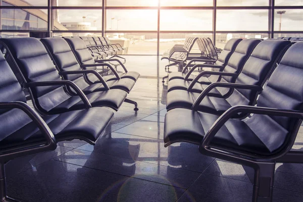 Assentos na sala de espera do aeroporto ao pôr-do-sol. Ninguém está sentado no aeroporto. . — Fotografia de Stock