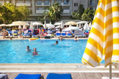 Seçici odak odak açık güneşli gün ve güneş şemsiyesi tropikal tatil yüzme havuzunda. Havuzda yaz aylarında yıkayın. Havuzu neşeli, pozitif duygular yaz aylarında. Geri kalan kavramı.