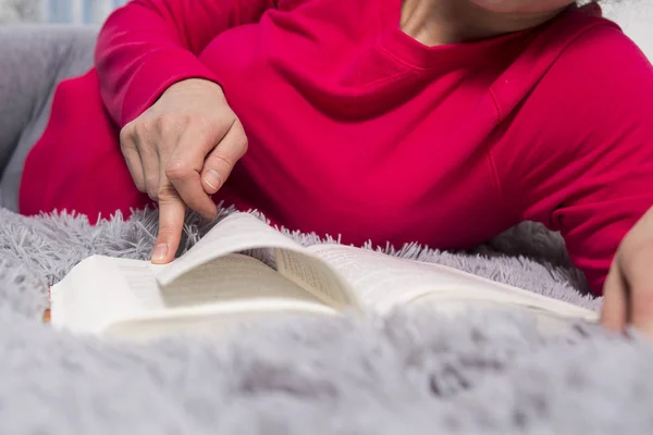 La ragazza sta leggendo. Mani e libro primo piano. Il concetto di lettura. Una giovane donna sta leggendo un romanzo. Leggi un bel libro. Capovolgi la pagina del libro . — Foto Stock