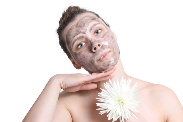 Aantrekkelijk meisje doet spa gezichtsbehandeling. Zwart masker voor gezicht. Gezicht schoonmaken. Gezichtsmasker voor mooie vrouw. Huidverzorging. Vrouw met de bloem geïsoleerd op witte achtergrond. — Stockfoto