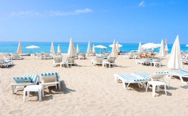 Tropikal beach Alanya. Şezlong ve güneşli, güneşli gün deniz kumlu plajda şezlonglar. Yaz tatil kavramı. Tropikal plaj.