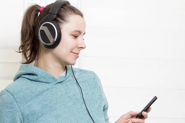 Jonge witte brunette meisje met speler en in de koptelefoon luisteren naar dance muziek op de achtergrond van de vuurtoren. — Stockfoto